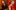 David Merino is on the left side of the image in a tux and is looking off to the left. Kate Kortum is on the right side of the image and is looking off to the right. She is wearing a red gown.